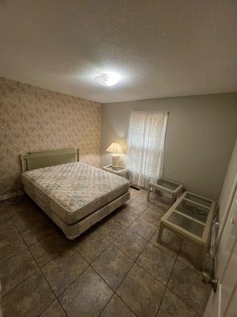 tiled bedroom with a textured ceiling