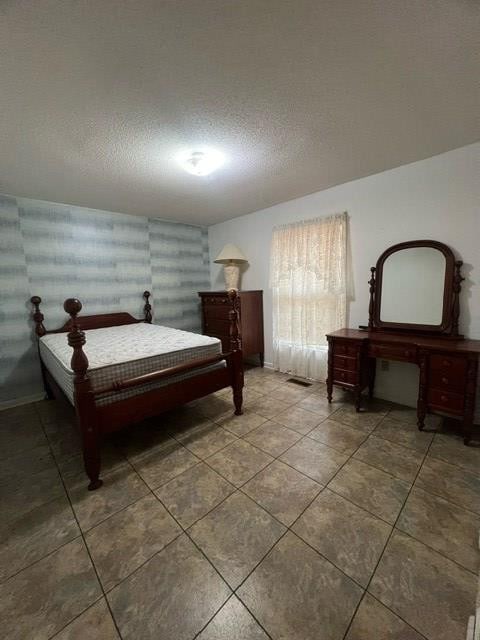 tiled bedroom featuring a textured ceiling