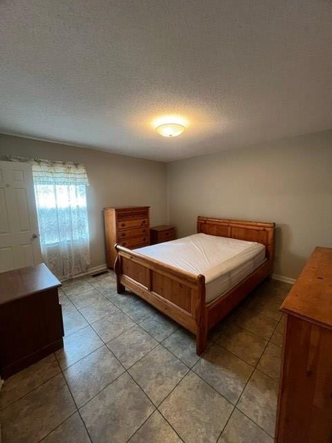 bedroom with tile patterned flooring and a textured ceiling