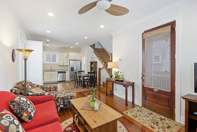 living room with hardwood / wood-style floors, ceiling fan, ornamental molding, and sink