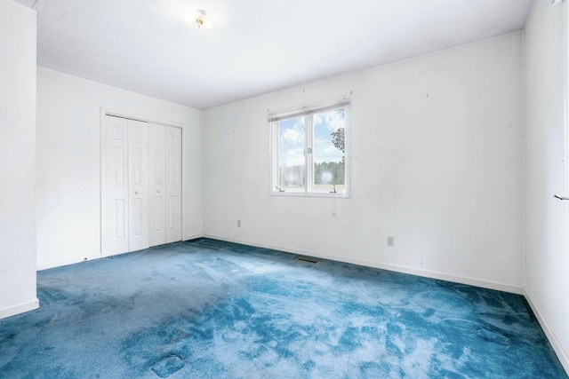 unfurnished bedroom with a closet and dark carpet