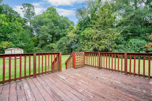 deck with a storage shed and a lawn