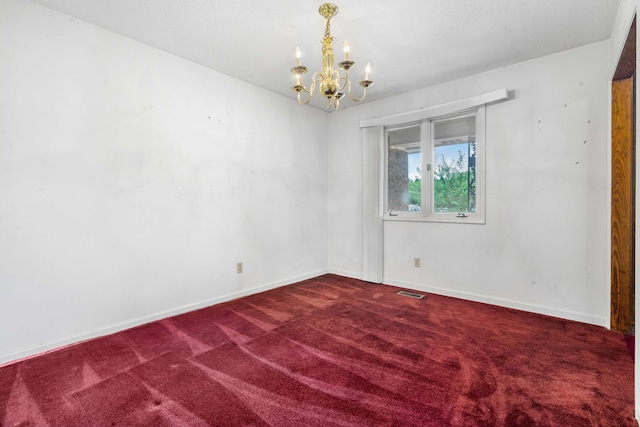 spare room with a notable chandelier and carpet floors