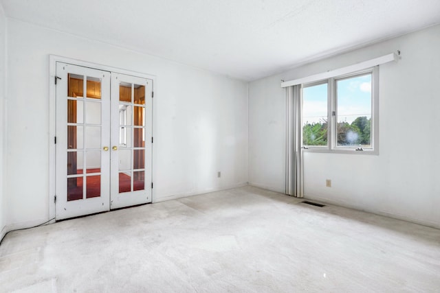 carpeted spare room with french doors