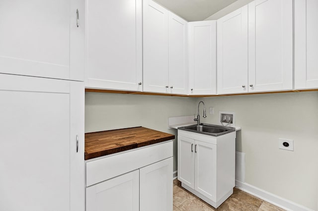 laundry room featuring hookup for an electric dryer, washer hookup, a sink, baseboards, and cabinet space