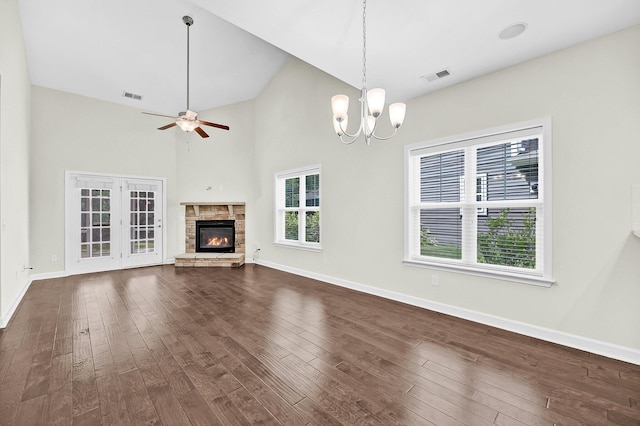 unfurnished living room with dark wood-type flooring, visible vents, a stone fireplace, and baseboards