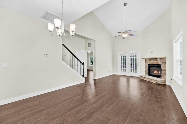 unfurnished living room with dark wood-style flooring, stairway, visible vents, baseboards, and ceiling fan with notable chandelier