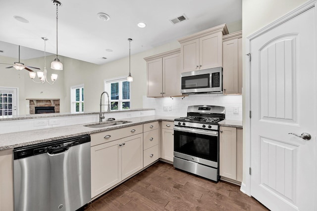 kitchen featuring tasteful backsplash, appliances with stainless steel finishes, a sink, visible vents, and a ceiling fan