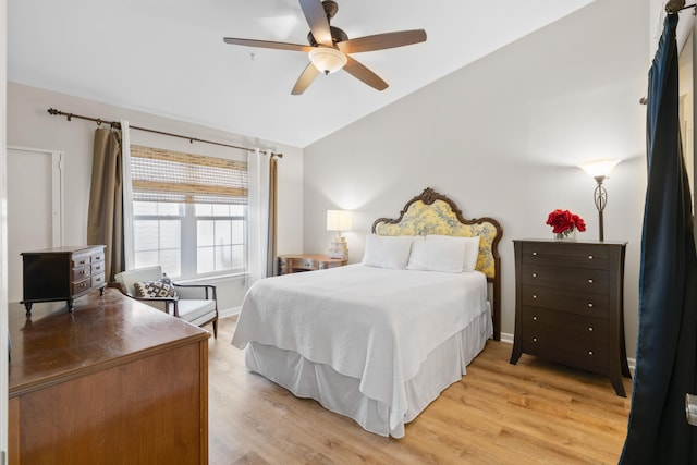 bedroom with ceiling fan, lofted ceiling, and light wood-type flooring