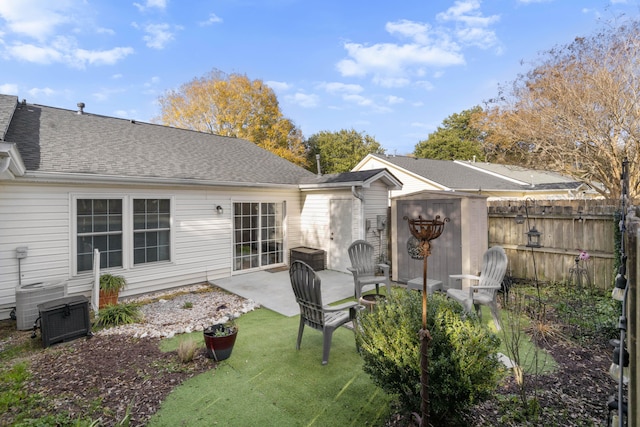 back of property with a storage unit, central AC, and a patio area