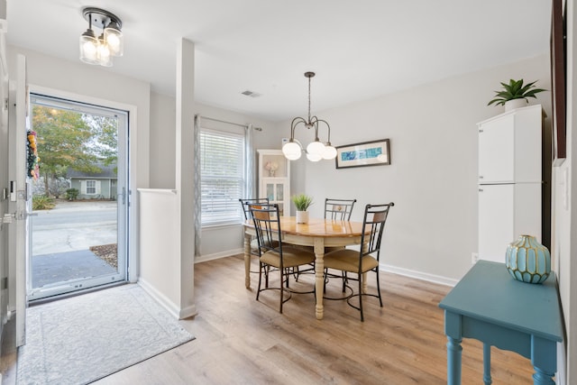 dining space featuring an inviting chandelier and light hardwood / wood-style floors