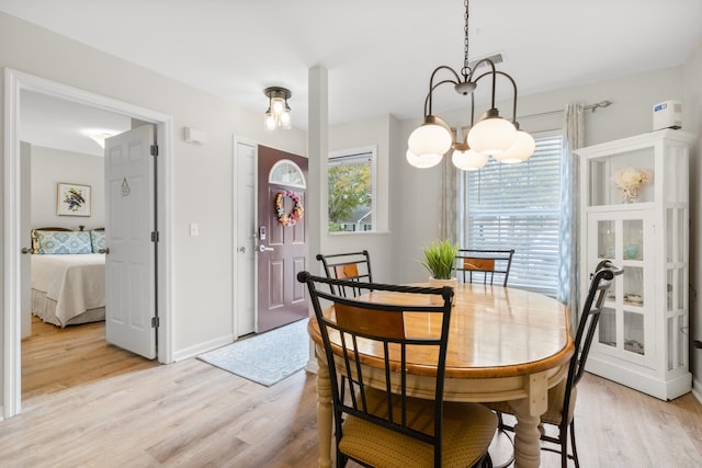 dining area featuring a chandelier and light wood-type flooring