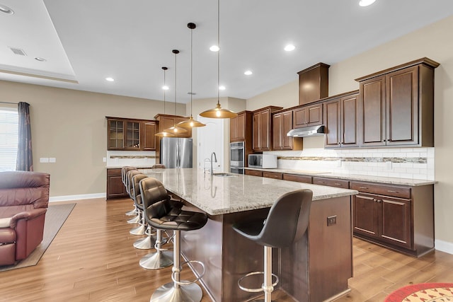 522 Tidewater Chase Ln, Summerville, SC 29486 - kitchen featuring a sink, light wood finished floors, stainless steel appliances, backsplash, and under cabinet range hood