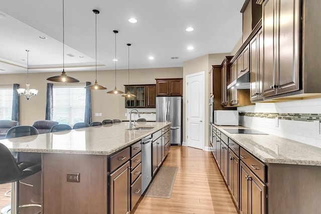 522 Tidewater Chase Ln, Summerville, SC 29486 - kitchen with a breakfast bar area, appliances with stainless steel finishes, a sink, under cabinet range hood, and light wood-style flooring