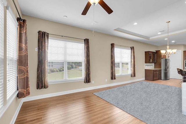 522 Tidewater Chase Ln, Summerville, SC 29486 - unfurnished living room featuring baseboards, recessed lighting, a raised ceiling, light wood finished floors, and ceiling fan with notable chandelier