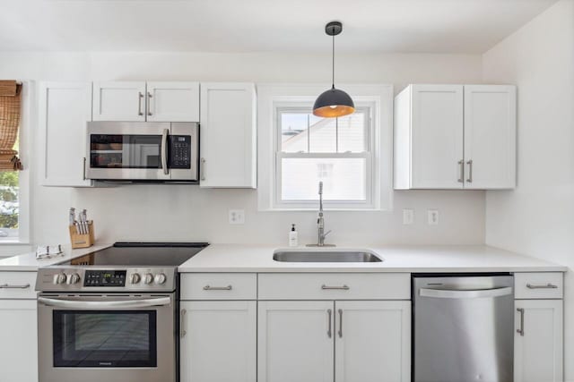kitchen featuring a sink, appliances with stainless steel finishes, white cabinetry, and a healthy amount of sunlight