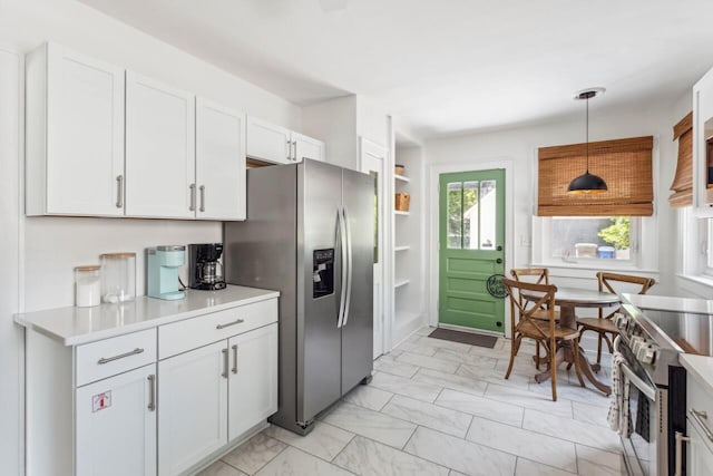 kitchen featuring decorative light fixtures, appliances with stainless steel finishes, light countertops, marble finish floor, and white cabinetry