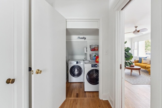laundry room featuring laundry area, wood finished floors, and washing machine and dryer
