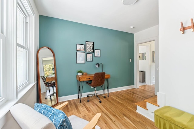 office space featuring baseboards and light wood finished floors