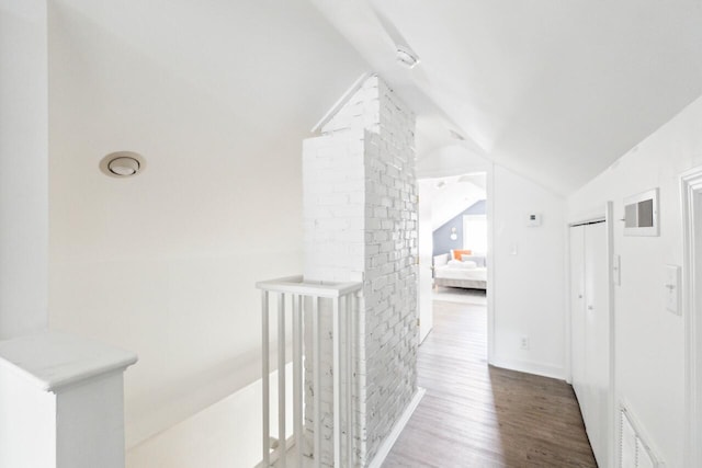 hall featuring baseboards, lofted ceiling, wood finished floors, and visible vents