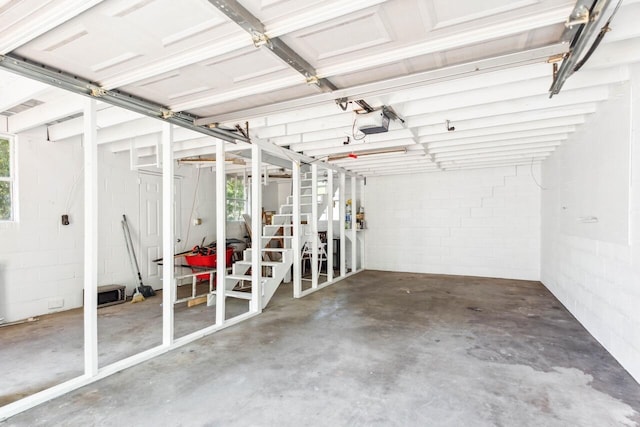 garage with a garage door opener and concrete block wall