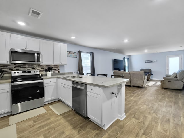 386 Spruce Ivy St, Moncks Corner, SC 29461 - kitchen with stainless steel appliances, a peninsula, open floor plan, light countertops, and white cabinets