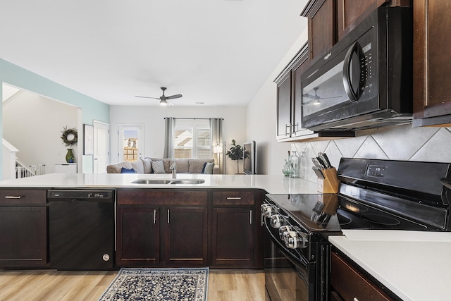 kitchen featuring black appliances, light wood-style floors, light countertops, and a sink