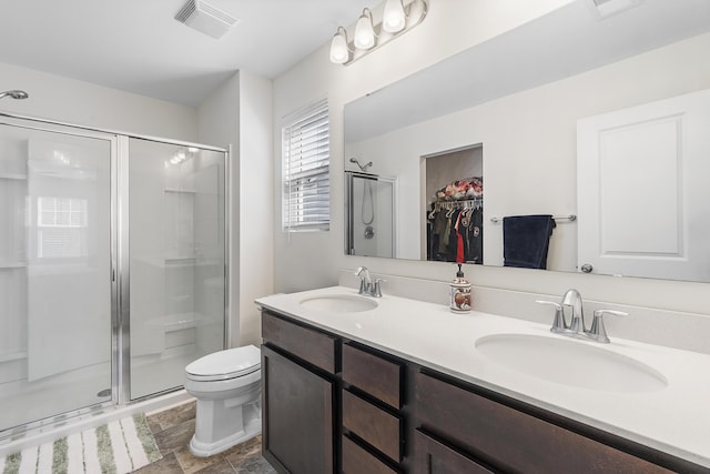 bathroom featuring a stall shower, visible vents, a sink, and toilet