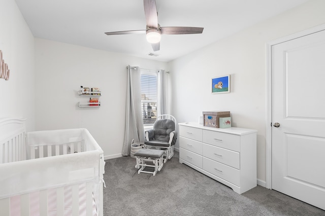 carpeted bedroom with a ceiling fan, a nursery area, visible vents, and baseboards