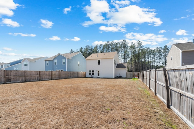 rear view of property with a residential view, a fenced backyard, and a yard