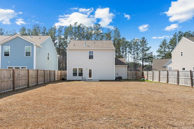 rear view of property featuring a fenced backyard and a yard