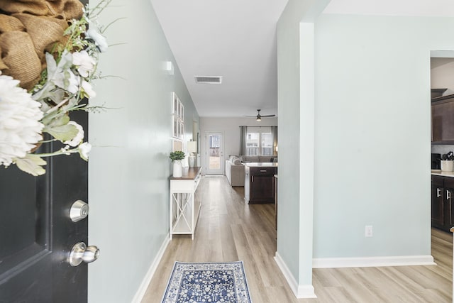 foyer featuring light wood-type flooring, baseboards, visible vents, and a ceiling fan