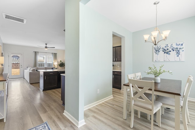 dining space with light wood-type flooring, baseboards, and visible vents