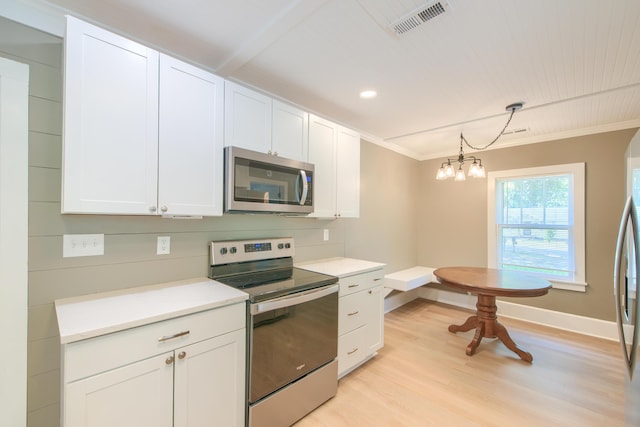 208 State St, Walterboro, SC 29488 - kitchen with appliances with stainless steel finishes, light wood-style floors, white cabinetry, baseboards, and crown molding