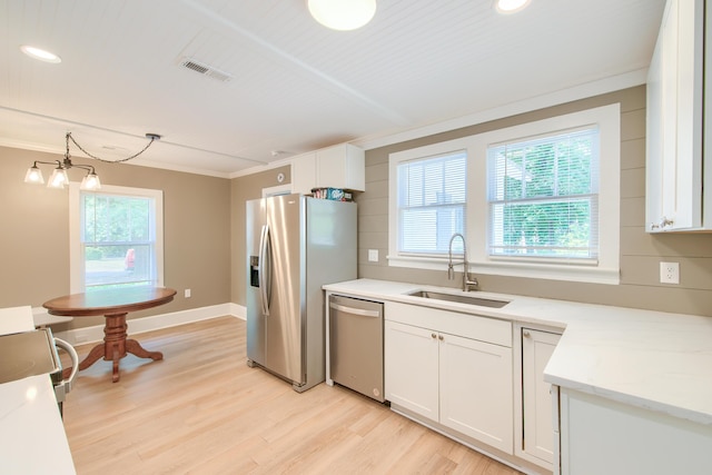 208 State St, Walterboro, SC 29488 - kitchen with appliances with stainless steel finishes, a sink, light wood-style flooring, white cabinets, and crown molding