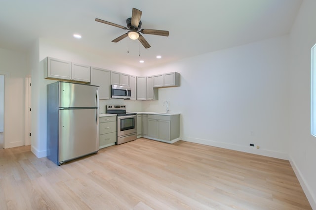 208 State St, Walterboro, SC 29488 - kitchen with stainless steel appliances, a sink, light wood-style flooring, a ceiling fan, and baseboards