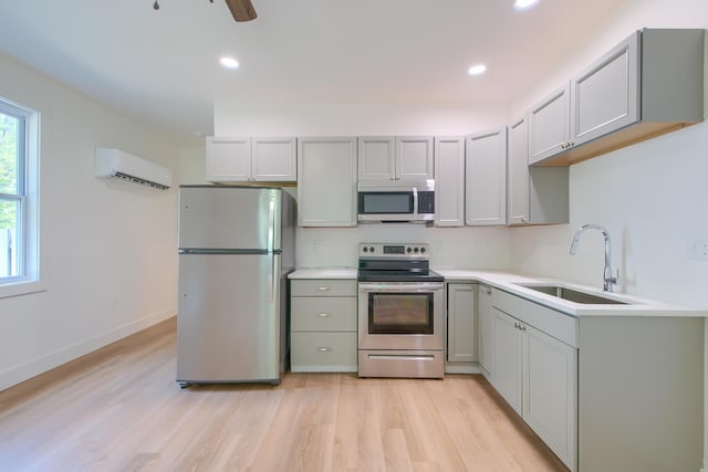 208 State St, Walterboro, SC 29488 - kitchen featuring appliances with stainless steel finishes, a sink, a wall mounted air conditioner, light wood-style flooring, and recessed lighting