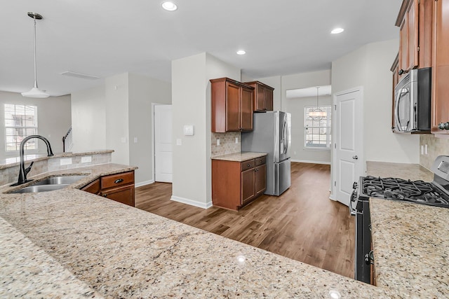 kitchen featuring dark wood-style floors, decorative backsplash, appliances with stainless steel finishes, and a sink