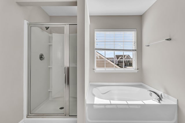 full bathroom featuring a garden tub and a shower stall