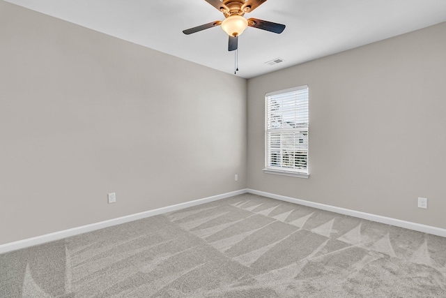 unfurnished room with visible vents, light carpet, baseboards, and ceiling fan