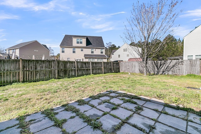 view of yard with a patio, a fenced backyard, and a residential view