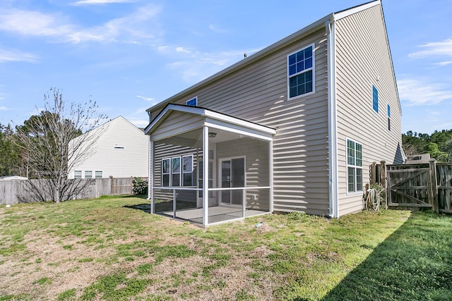 rear view of property featuring a lawn, a fenced backyard, and a sunroom