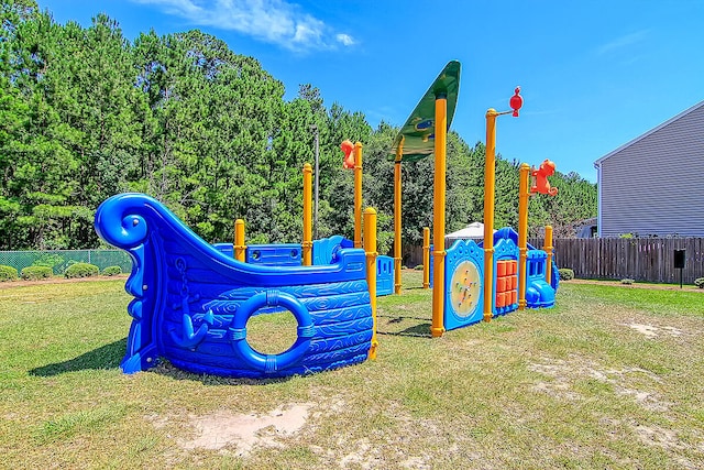 community play area featuring a yard and fence