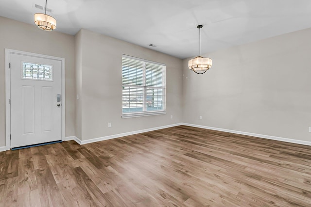 foyer entrance with visible vents, baseboards, and wood finished floors