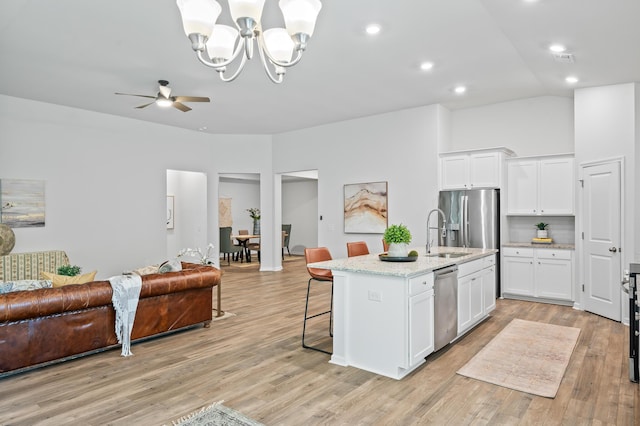 209 Country Gate Ln, Summerville, SC 29485 - kitchen with stainless steel appliances, open floor plan, a kitchen bar, white cabinetry, and a sink