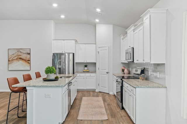 209 Country Gate Ln, Summerville, SC 29485 - kitchen featuring appliances with stainless steel finishes, a sink, a kitchen bar, lofted ceiling, and decorative backsplash