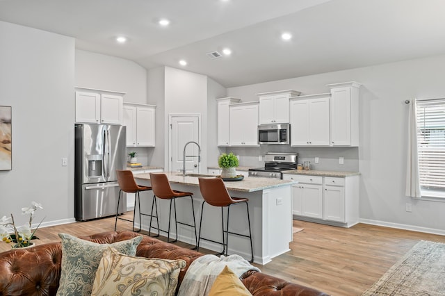 209 Country Gate Ln, Summerville, SC 29485 - kitchen with stainless steel appliances, a sink, lofted ceiling, an island with sink, and a breakfast bar area