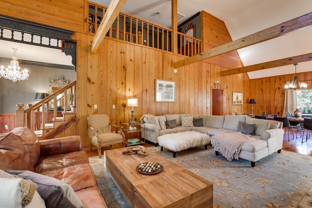 living room with wood-type flooring, an inviting chandelier, high vaulted ceiling, and wood walls