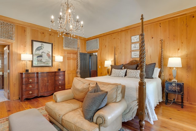 bedroom with wood walls, light wood-type flooring, and a chandelier