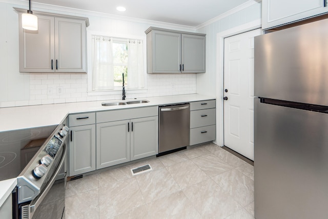 kitchen with sink, tasteful backsplash, crown molding, pendant lighting, and appliances with stainless steel finishes